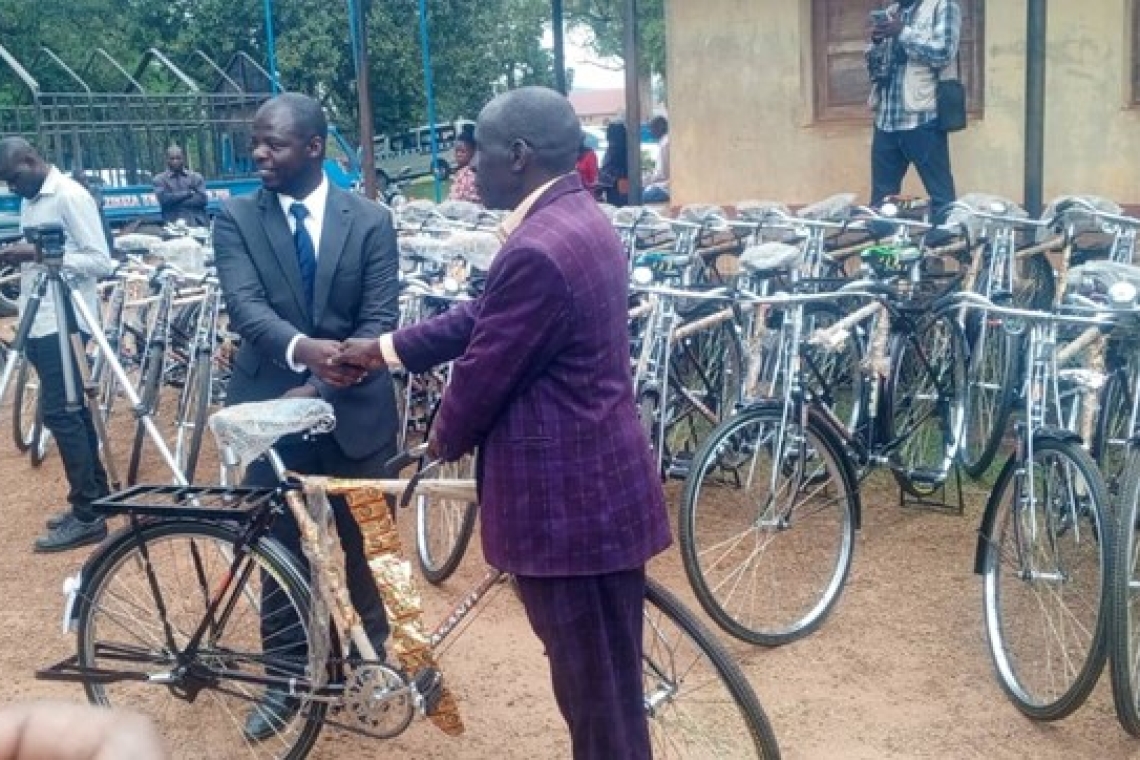 Oweek. Deo Kagimu handing over a bicycle to one of Kabaka's chiefs